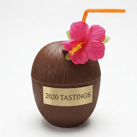 Coconut-shaped drink with a pink flower and orange straw on a white background